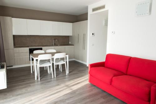 a living room with a red couch and a table and chairs at Residenza Luigina in Varenna