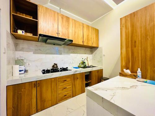a kitchen with wooden cabinets and a white counter top at Palm&Ocean Canggu in Canggu