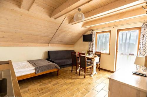 a bedroom with a bed and a table and a couch at Villa Sul Mare in Dębki