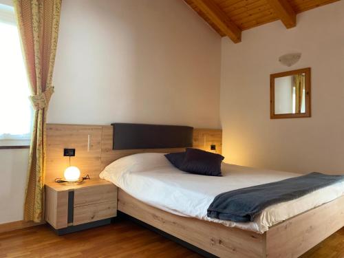 a bedroom with a bed and a table and a window at Casa Pallanch in Fai della Paganella