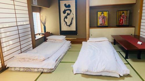 2 camas en una habitación con mesa en 山水之家, en Otsu