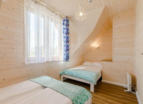 a room with two beds and a window at DOMKI SUL MARE in Dębki