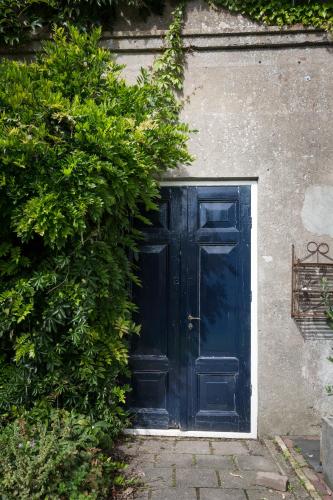 a blue door in the side of a building at d' âld skoalle - Sfeervol appartement in oude school. in Wijtgaard