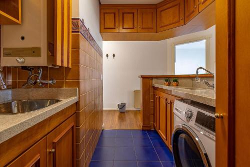 een keuken met een spoelbak en een wasmachine bij Rosa Edifício English Place in Gramado