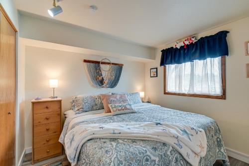 a bedroom with a bed and a window with blue curtains at Ocean Shores Condo with Balcony Less Than 1 Mi to Beach! in Ocean Shores