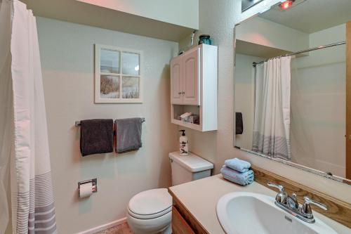 a bathroom with a sink and a toilet and a mirror at Ocean Shores Condo with Balcony Less Than 1 Mi to Beach! in Ocean Shores