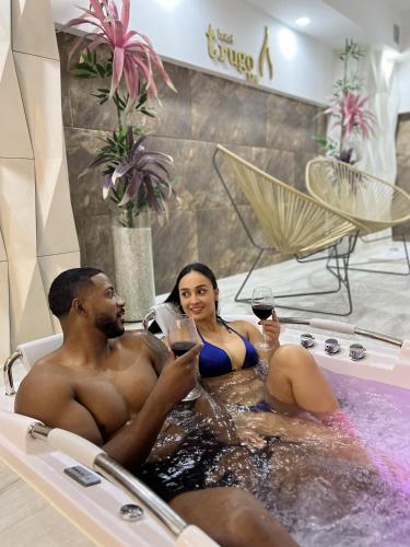 a man and woman sitting in a bath tub with wine glasses at Trugo Luxury Rooms in Armenia