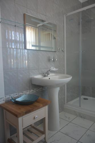 a white bathroom with a sink and a shower at Salvia apartment in Kaunas