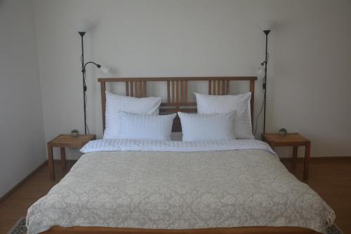 sypialnia z dużym łóżkiem z białą pościelą i poduszkami w obiekcie Salvia apartment w Kownie