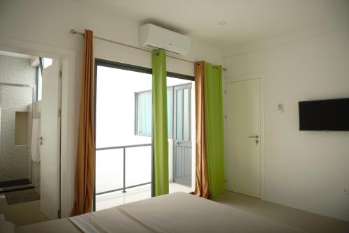 a bedroom with a bed and a large window at Duarte Apartments - Morabeza in Mindelo