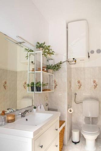 a bathroom with a sink and a toilet and a mirror at BRAND NEW City Center Apartment Nostalgija in Split