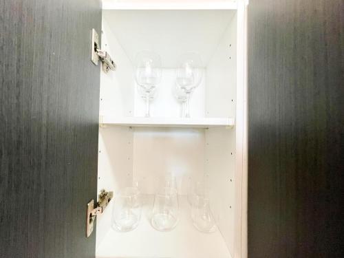 une armoire remplie de verres à vin sur une étagère dans l'établissement Blue Ocean Holiday Home, à Playa del Ingles