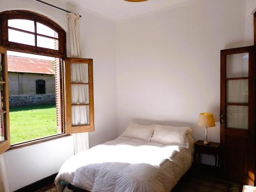 een slaapkamer met een bed en een raam bij Casa de campo San Agustín in Tandil