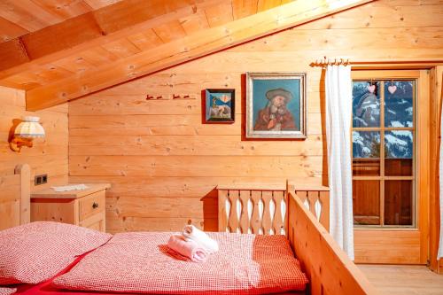 um quarto com uma cama num chalé de madeira em Magdalena Hütte em Hippach