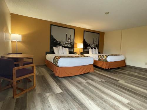 a hotel room with two beds and a desk at Super 8 by Wyndham Pevely in Pevely