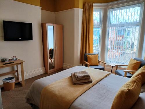 a hotel room with a bed and a television at The Copplehouse in Southport