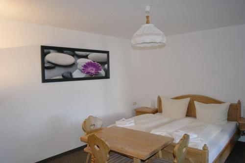 Gasthof zum Hirsch : غرفة نوم بسرير وطاولة وصورة