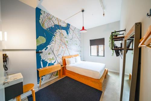 1 dormitorio con 1 cama y un mapa en la pared en The Baltic Hotel en Brooklyn