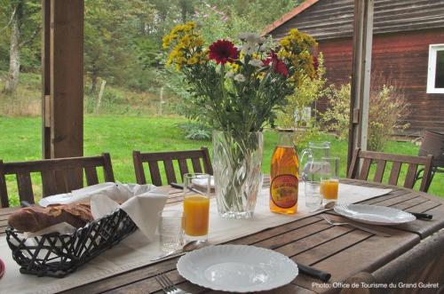 a wooden table with a vase of flowers on it at Camping La Chapelle 