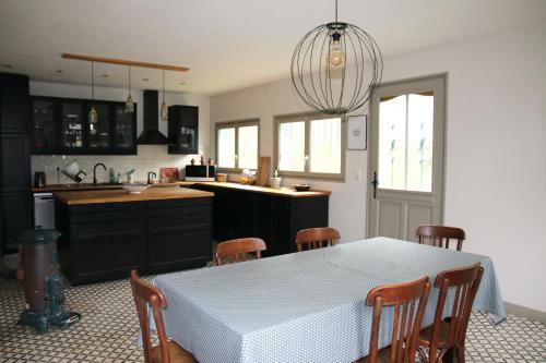 une cuisine avec une table et des chaises blanches et une cuisine avec une table dans l'établissement Maison de campagne bourguignonne 19ème entièrement rénovée, à Chaumot