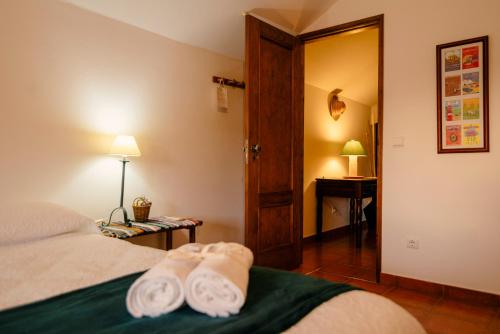 Una habitación con una cama con dos toallas. en A Saboeira - Turismo Rural en Belver