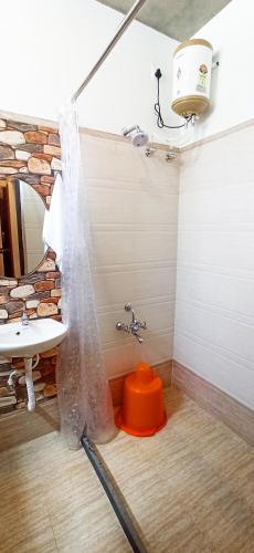 a bathroom with a sink and a orange stool at Wow Farm House & Resort near Pondicherry in Auroville