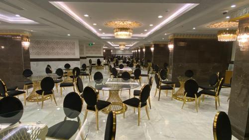 a dining room with tables and chairs and chandeliers at فندق منار التوحيد 2 in Mecca