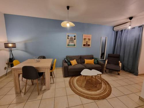 a living room with a couch and a table at Agréable appartement avec 2 places de parking dans le garage in Béziers