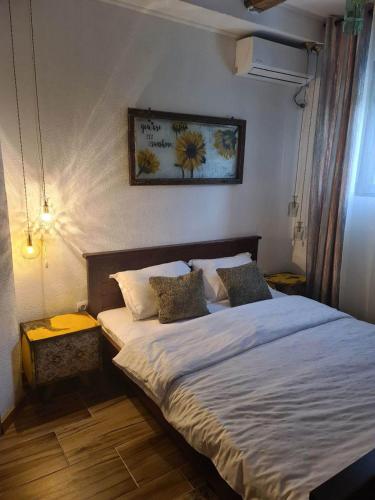 - une chambre dotée d'un grand lit avec des draps et des oreillers blancs dans l'établissement Apartments Klisić, à Bar