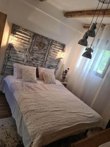 - une chambre avec un grand lit et une tête de lit en bois dans l'établissement Apartments Klisić, à Bar
