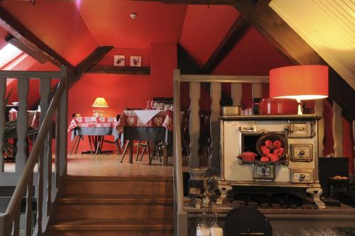 a kitchen and dining room with a stove in a room at Hôtel Restaurant Domaine De Basil in Orbey