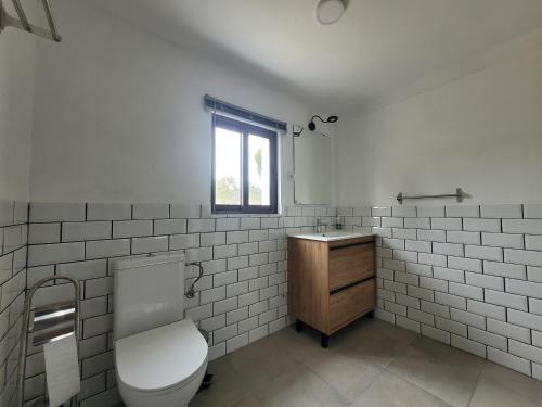 baño con aseo y lavabo y ventana en Monte das Laranjeiras, en Cortiçadas do Lavre