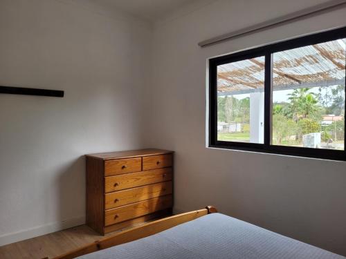 1 dormitorio con tocador de madera y ventana en Monte das Laranjeiras, en Cortiçadas do Lavre