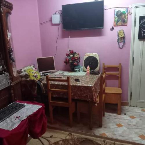 uma sala de jantar com uma mesa e uma televisão na parede em منزل مصطفى العوام 
