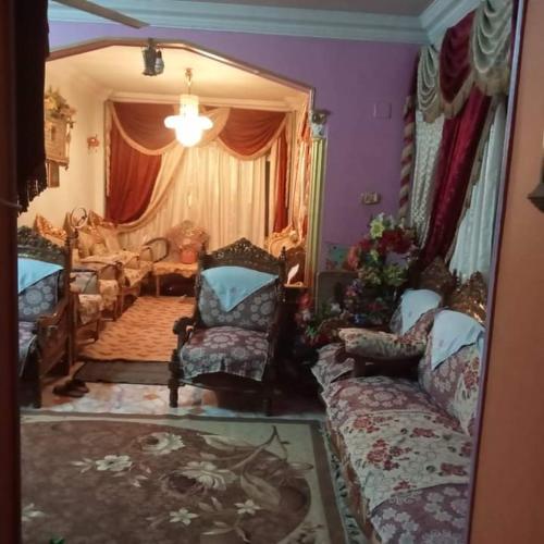 uma sala de estar com um sofá e uma cadeira em منزل مصطفى العوام 