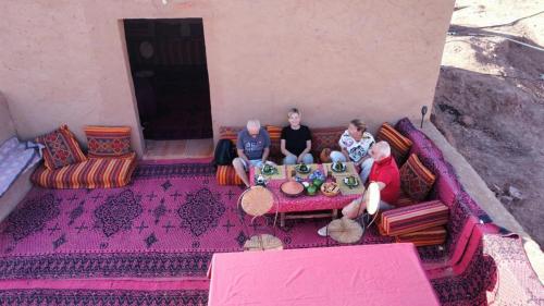 un gruppo di tre persone seduti su un divano di Chigaga Luxury Camp a M'Hamid