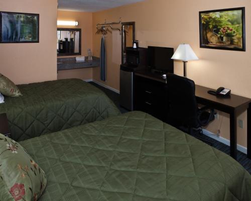 een hotelkamer met 2 bedden en een bureau bij Bostonian Inn in New Boston