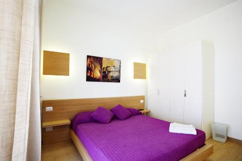 a bedroom with a purple bed with purple pillows at Affittacamere Nansen in Rome