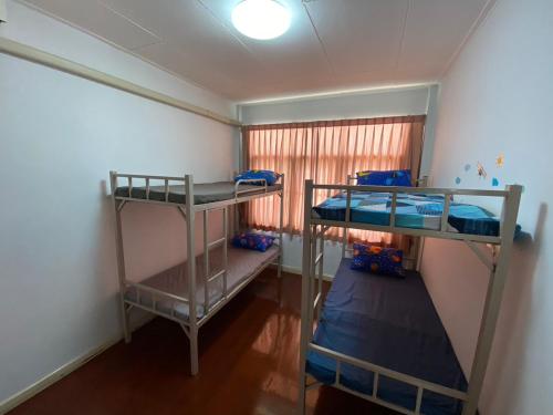 two bunk beds in a room with a window at Sura Hostel and Coworking in Bangkok