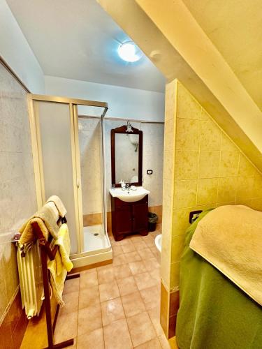 ein Bad mit einer Dusche, einem Waschbecken und einem Bett in der Unterkunft Villa Kida in Ladispoli