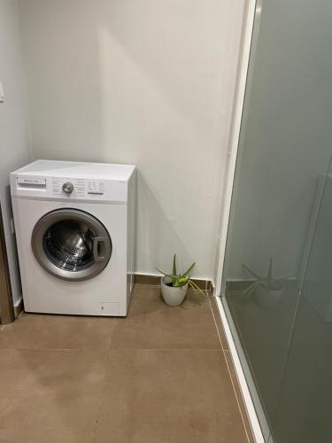 una lavadora en una habitación con una planta en My home, en Amaliás