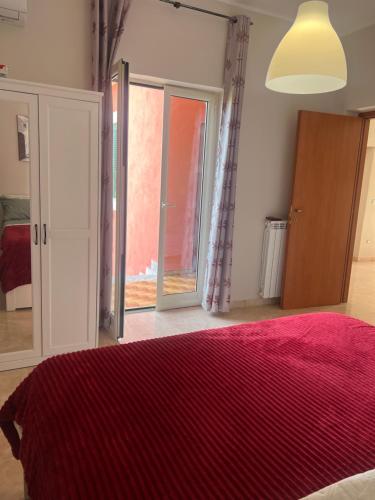 um quarto com uma cama com um cobertor vermelho em Esther Guest House em Castel Volturno
