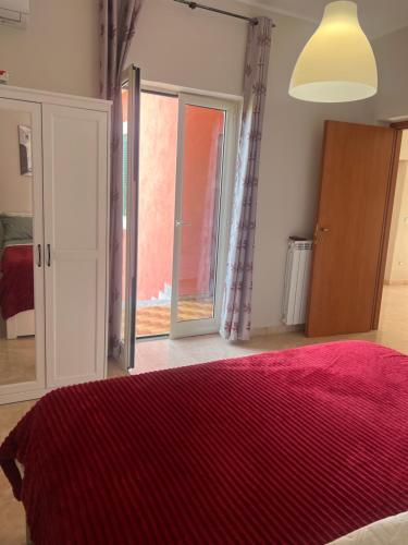 a bedroom with a bed with a red blanket at Esther Guest House in Castel Volturno