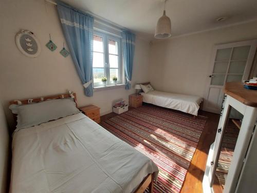 a bedroom with two beds and a window at Na skraju lasu in Milejczyce