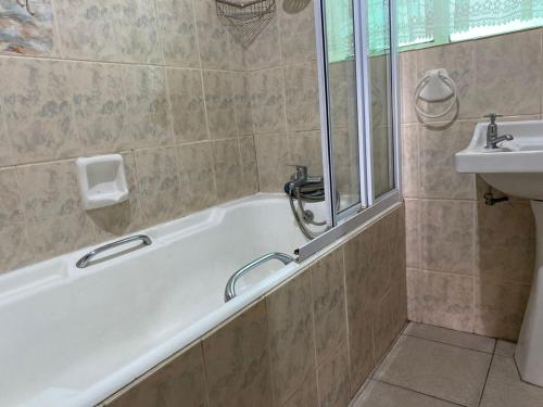 a bathroom with a bath tub and a sink at Straebe Stay in Bloemfontein