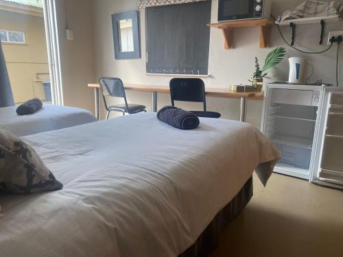 a bedroom with two beds and two chairs and a desk at Straebe Stay in Bloemfontein