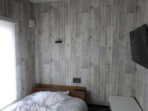 a bedroom with a bed and a wooden wall at Beppu City - House - Vacation STAY 16316v in Beppu
