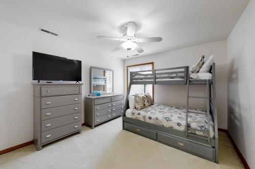 a bedroom with a bunk bed and a flat screen tv at Trinity Place Treasure in Ocean Pines