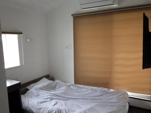 a bedroom with a white bed with a wooden door at Beppu City - House - Vacation STAY 16301v in Beppu