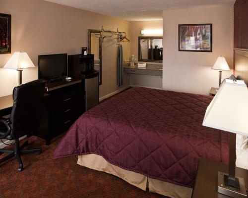 Habitación de hotel con cama, escritorio y ordenador en Bostonian Inn, en New Boston